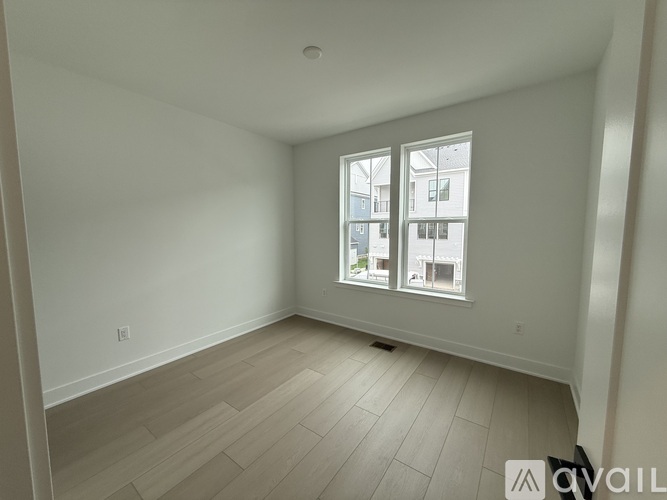 A room with a window showing a view of a building.