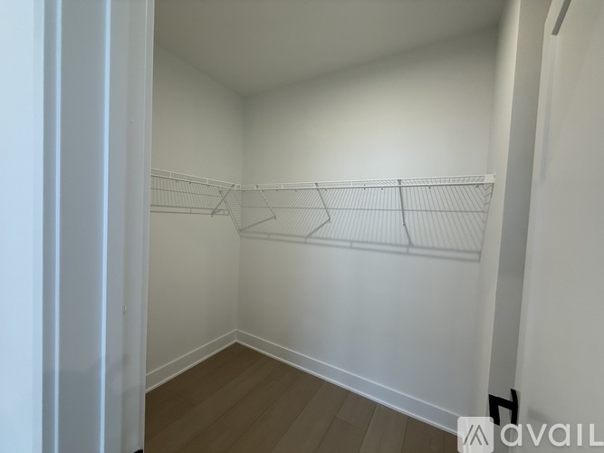 Empty room with white walls and wooden floor.