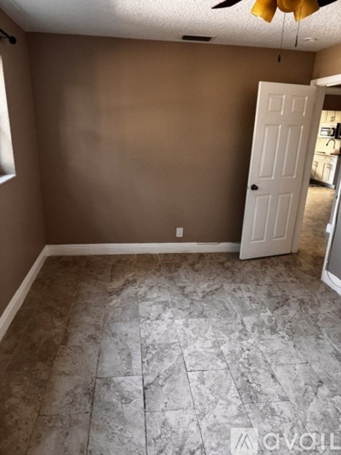 A room with a tiled floor and a white door.