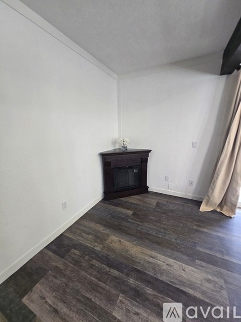 A room with a wood floor and a fireplace.