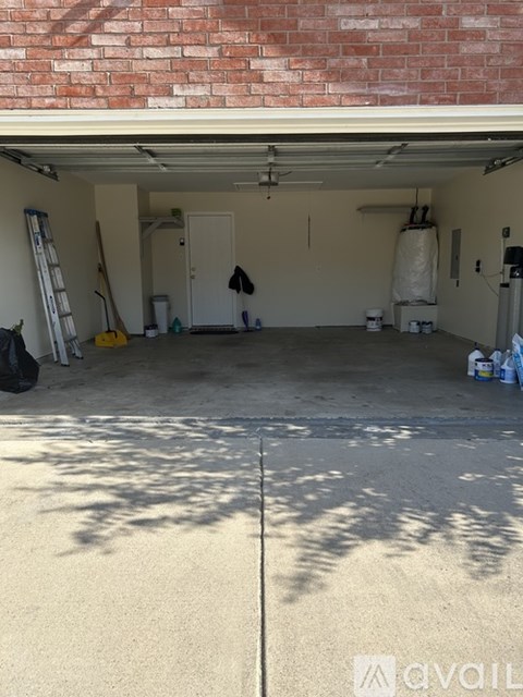 A garage with a ladder and a coat hanging on the wall.