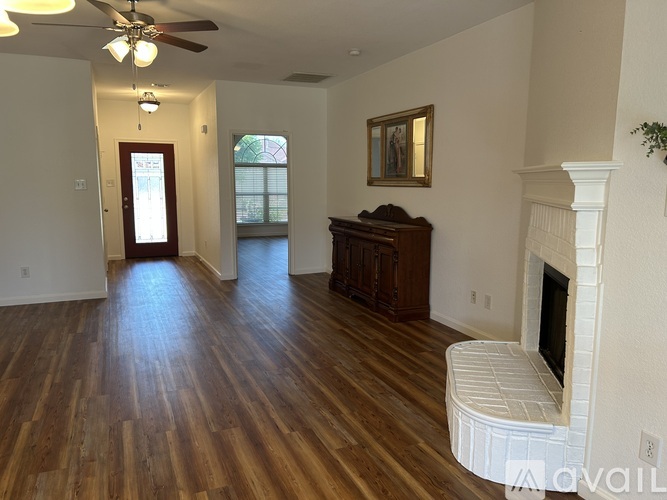 A living room with wood floors and a fireplace.
