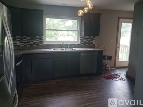 A kitchen with dark cabinets and a window.