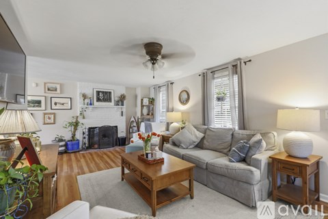 A living room with a grey couch, a coffee table, and a fireplace.