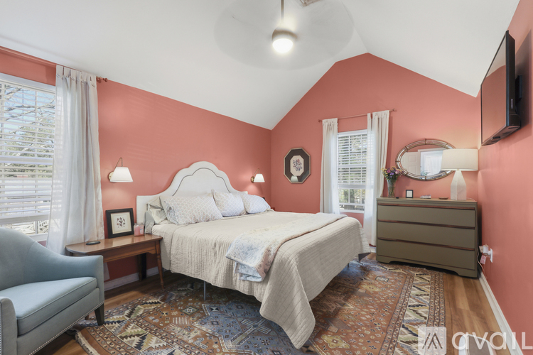 A bedroom with a bed, dresser, and chair.