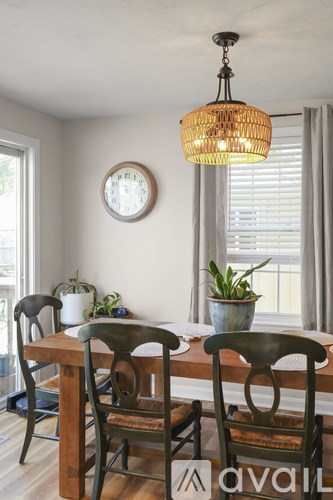 A dining room with a wooden table and chairs.