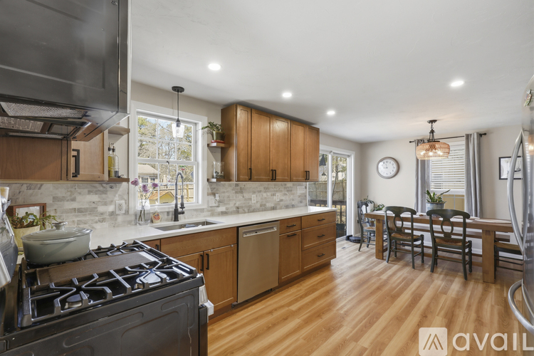 A modern kitchen with wooden cabinets and a black stove top.