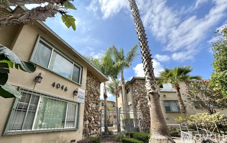 A building with the number 4046 on it is surrounded by palm trees.
