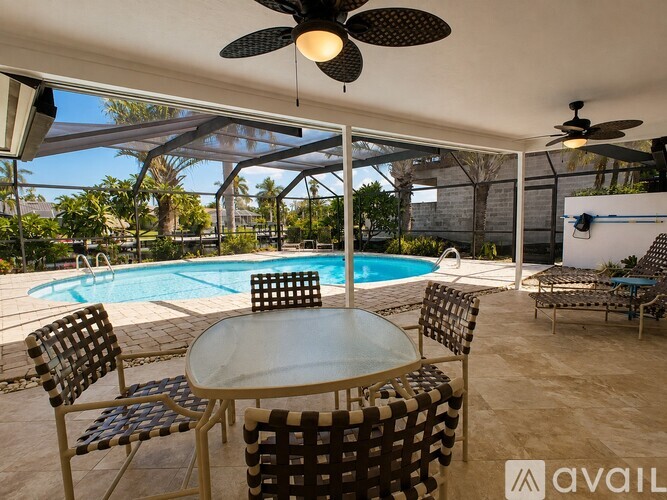 A patio with a table, chairs, and a pool.
