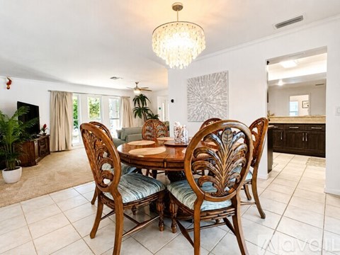 A dining room with a wooden table and chairs.