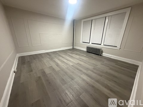 A room with wooden flooring and white walls.