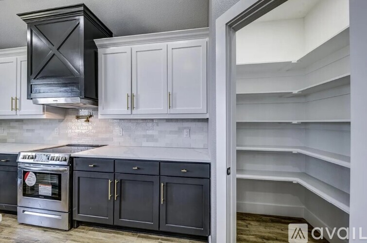 A kitchen with black cabinets and a stainless steel oven.