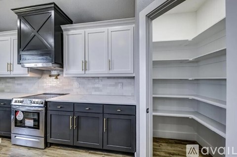 A kitchen with black cabinets and a stainless steel oven.