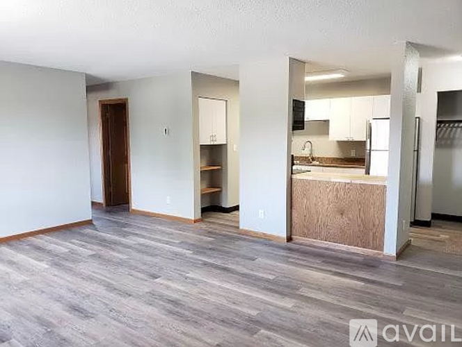 A room with a grey floor and white walls is available for rent.
