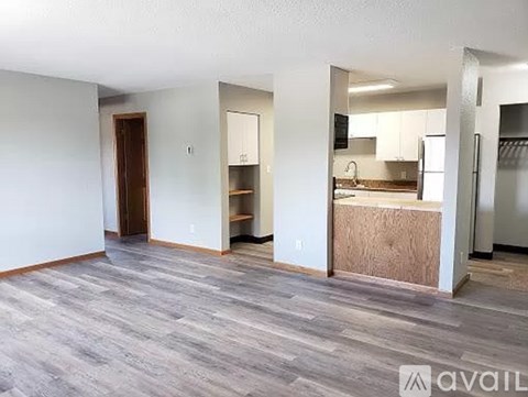 A room with a grey floor and white walls is available for rent.