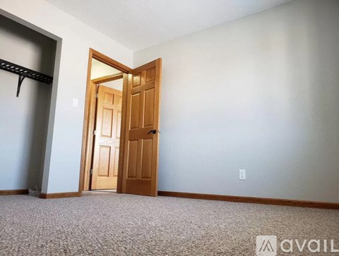 A room with a carpeted floor and a wooden door.
