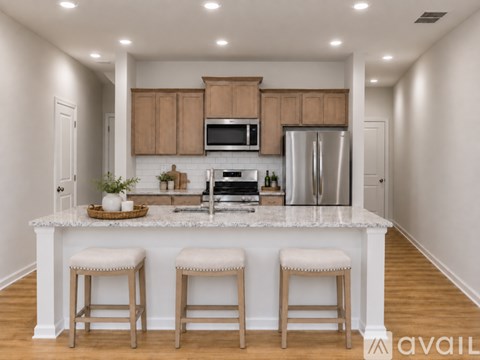 A kitchen with a white island and wooden bar stools.