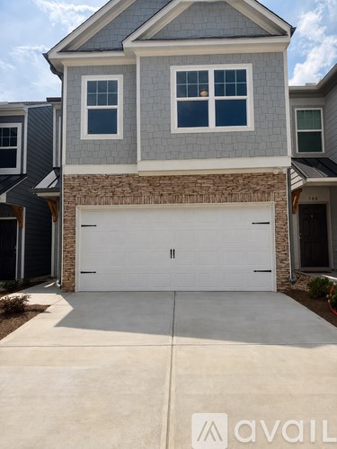 A two-car garage is attached to a gray house.