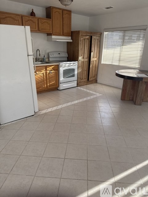 A kitchen with white appliances and wooden cabinets.