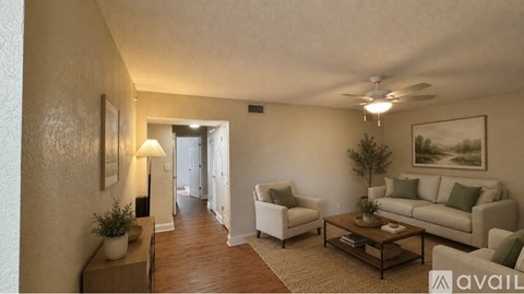 A living room with a white couch, a brown coffee table, and a painting on the wall.