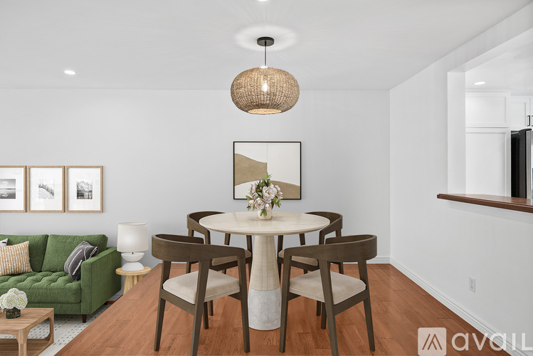 A modern dining room with a green couch and a round table.