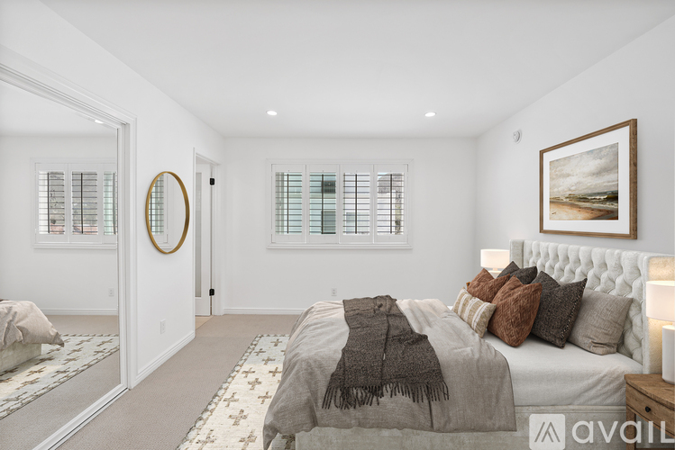 A bedroom with a large bed and a painting on the wall.