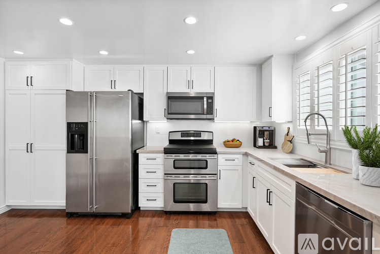 A kitchen with white cabinets and stainless steel appliances.