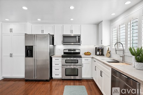 A kitchen with white cabinets and stainless steel appliances.