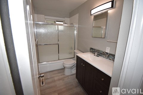 A bathroom with a toilet, sink, and shower.