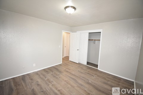 A room with a wooden floor and a white door.