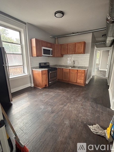 A kitchen with wooden cabinets and a black refrigerator.