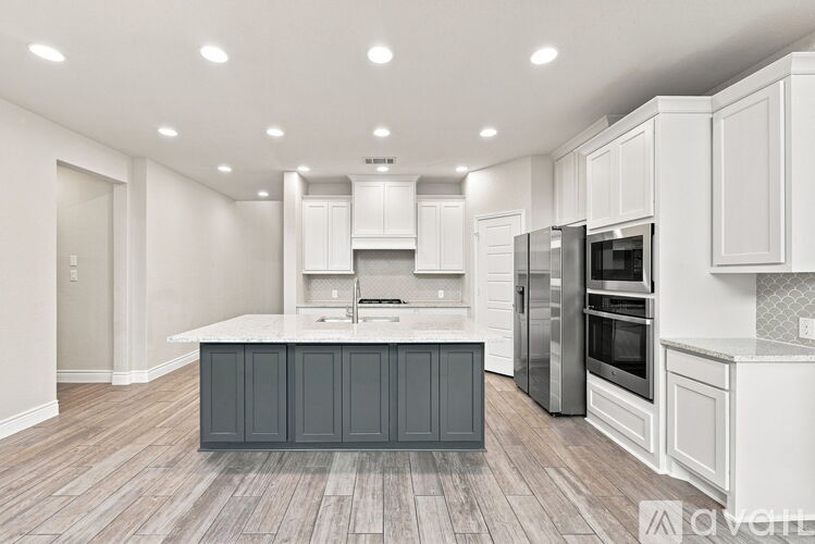 A modern kitchen with white cabinets and a central island.