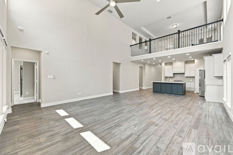 A spacious living room with a balcony and hardwood floors.