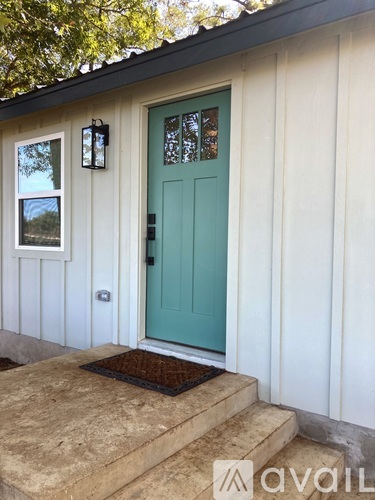 A white house with a blue door and a window.