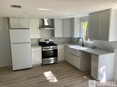 A kitchen with white appliances and cabinets.