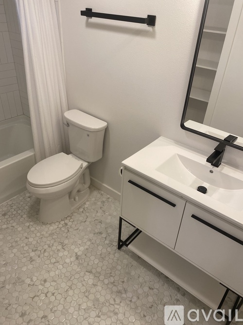 A white toilet sits next to a white sink in a bathroom.