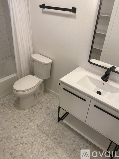 A white toilet sits next to a white sink in a bathroom.