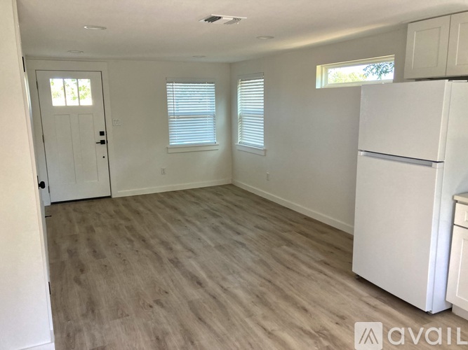 A kitchen with white cabinets and a white fridge.