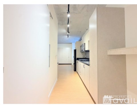 A long hallway with a kitchen area at the end.