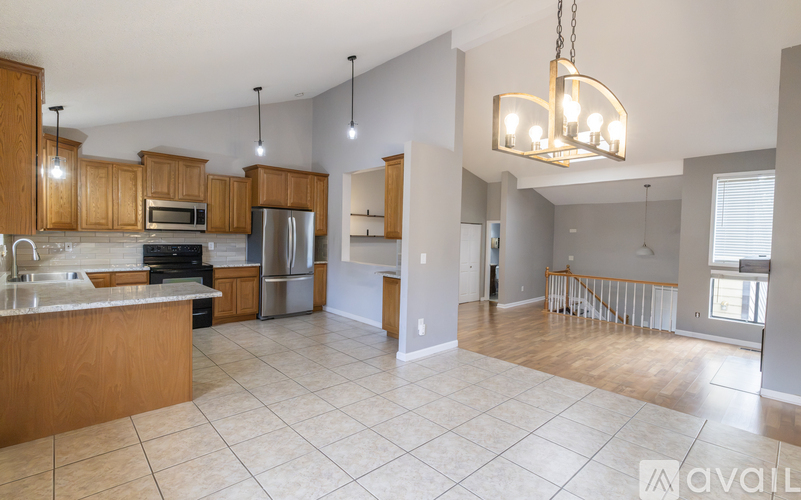 A kitchen with wooden cabinets and a tiled floor.