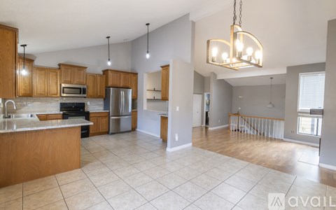A kitchen with wooden cabinets and a tiled floor.