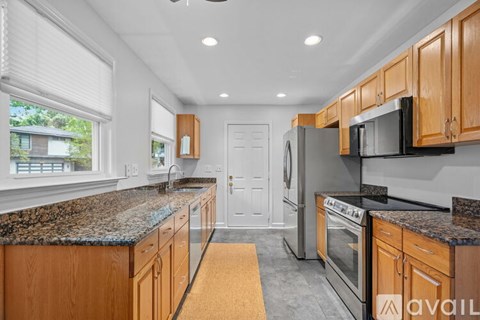 A kitchen with wooden cabinets and granite countertops.