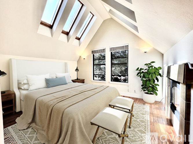 A bedroom with a large bed and a chair.