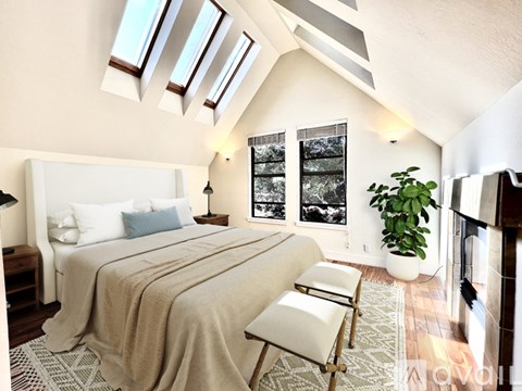 A bedroom with a large bed and a chair.