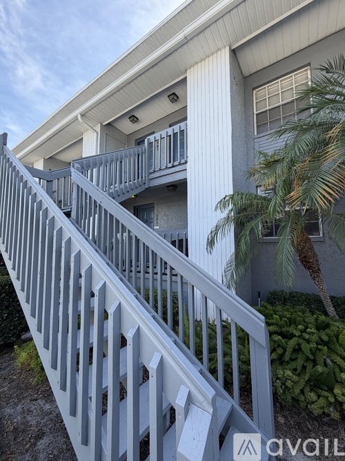 A white house with a balcony and a staircase.