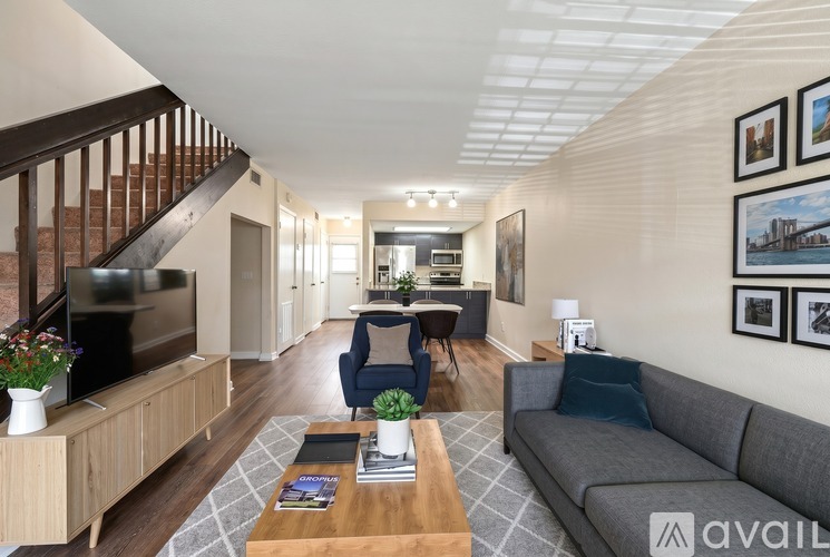 A living room with a couch, a coffee table, and a staircase.