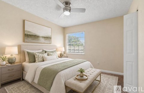 A bedroom with a bed, nightstands, and a window.