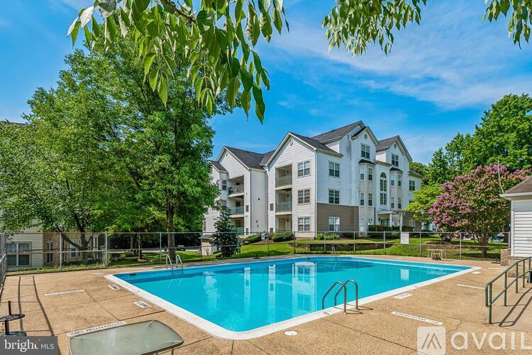 A bright sunny day at a pool with a building in the background.