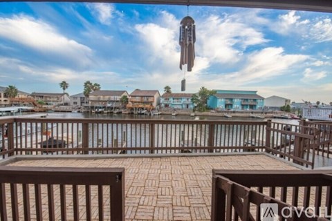 A balcony overlooks a body of water with buildings in the distance.