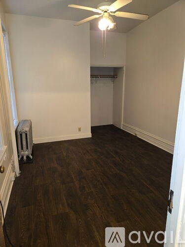 A room with a ceiling fan and a radiator on the floor.